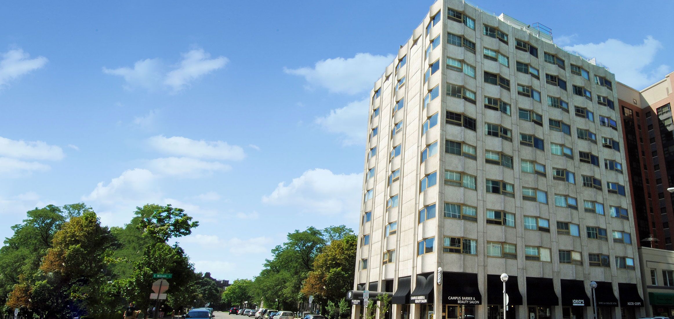 High angle shot of high rise apartment building against a clear blue sky on a city street corner