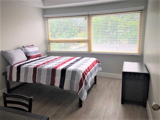 fully furnished apartment bedroom red gray plaid bedspread