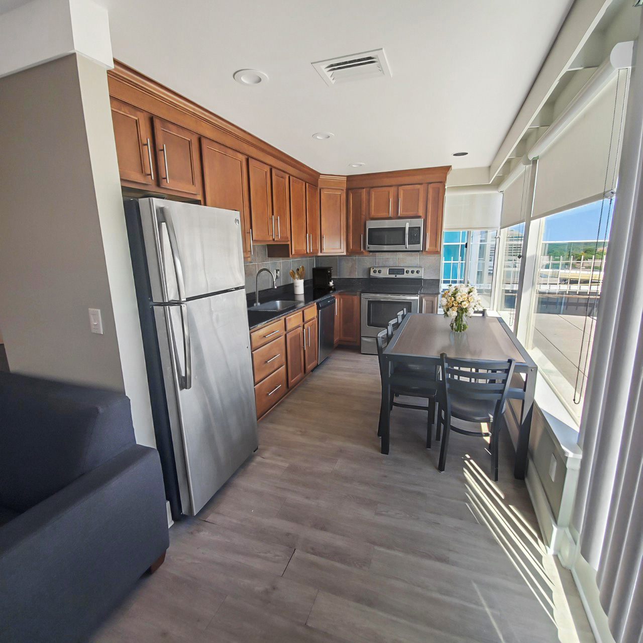 modern penthouse kitchen warm wood cabinets dining table