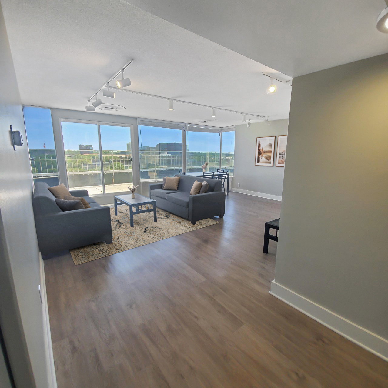 spacious penthouse living room track lighting floor to ceiling windows